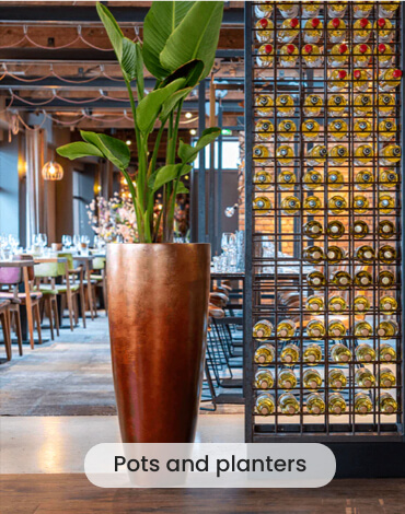 Tall pot with artificial plant in a restaurant